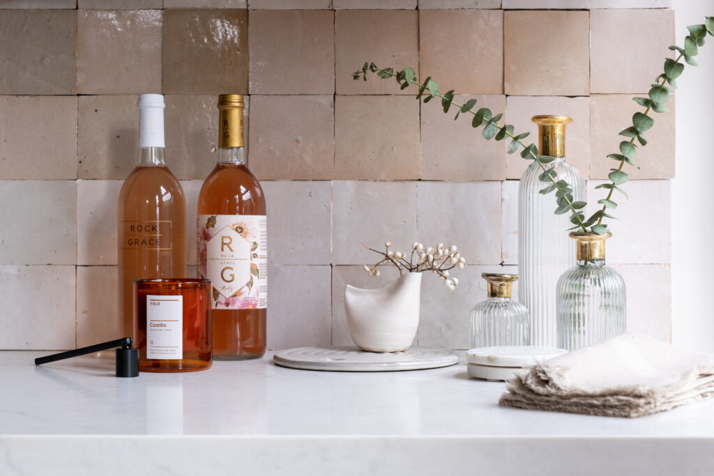 Stylish kitchen counter accessorized with fresh herbs, wood tones, and minimalist decor, by ASR Design Studio