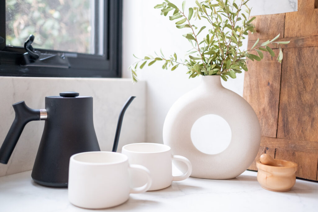 Modern kitchen countertop styled with wooden cutting boards and natural accessories, by ASR Design Studio