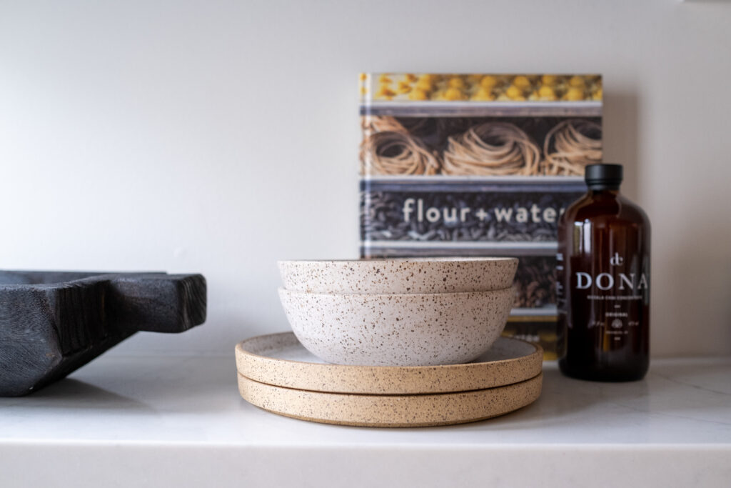 Functional kitchen counter decor featuring olive oil, salt, and pepper in stylish containers, by ASR Design Studio