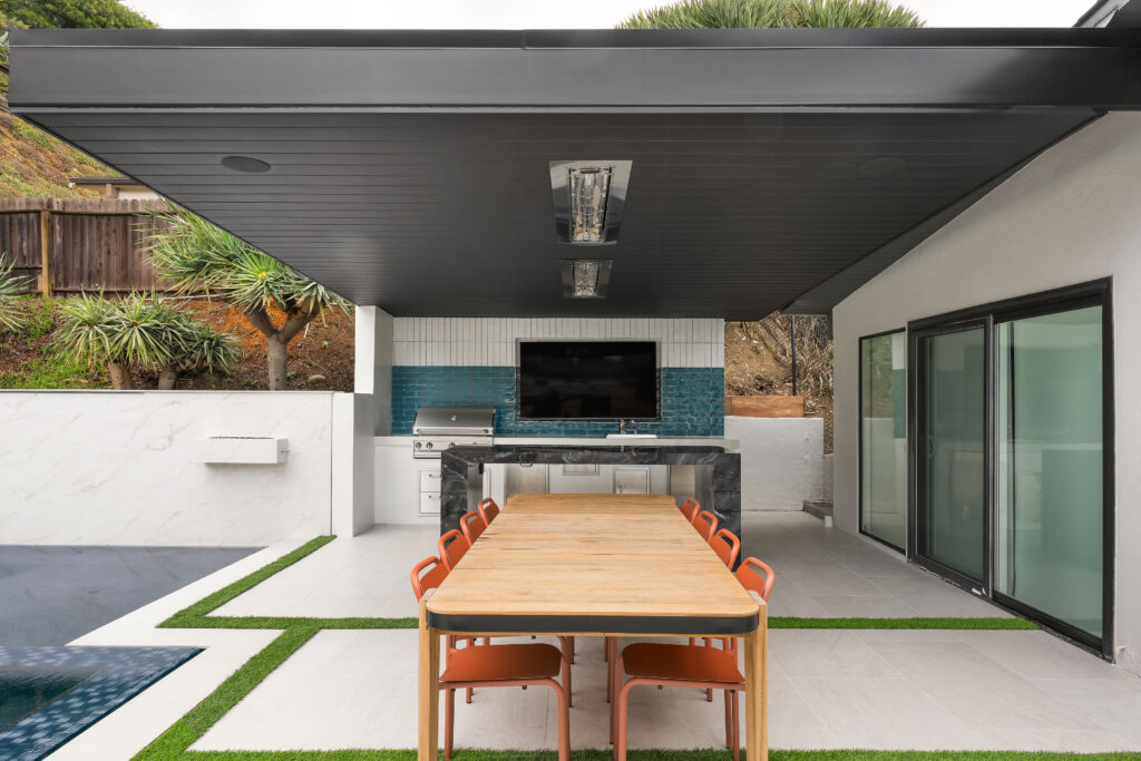 Resort-style outdoor kitchen with built-in grill and stone countertops, by ASR Design Studio