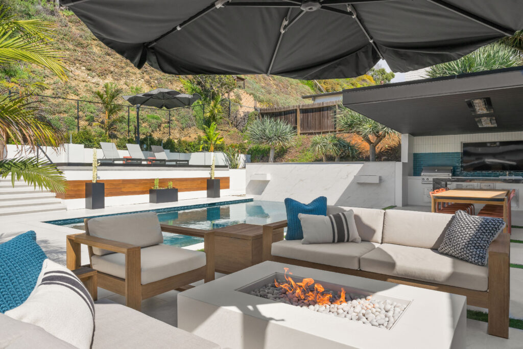 Luxury outdoor living space with custom seating and fire pit, by ASR Design Studio