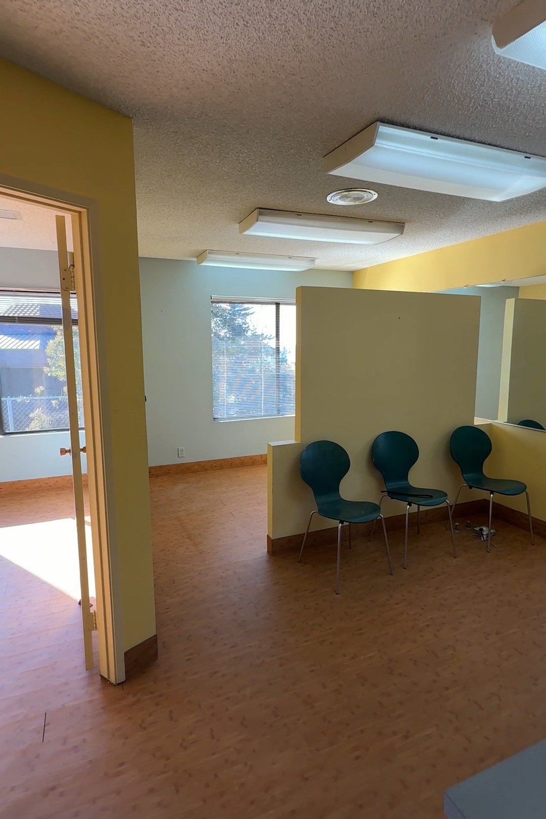 Smiles by Pai before: dated waiting room with yellow walls, green chairs, and worn flooring